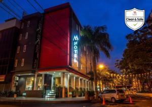 un edificio con un cartel en el costado en M Hotel, en Yakarta