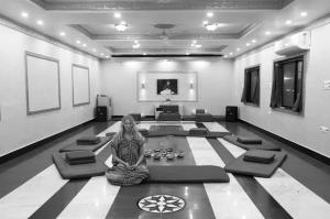 a woman sitting on the floor in a room at Hotel Harmony in Khajurāho