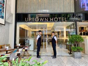 two men are standing in front of a hotel at UpTown Hotel in Ho Chi Minh City