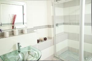 a bathroom with a glass shower and a sink at a Vue Guesthouse in Somerset West
