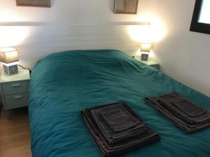 a bed with two trays on it in a bedroom at Capbreton Notre-Dame in Capbreton