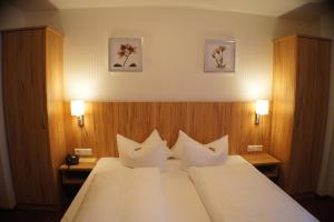 a hotel room with a large bed with white pillows at Hotel am Bad in Tübingen +39 photos