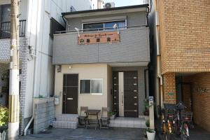 大阪的住宿－Auberge du Tanuki Noir Maison d'Hôtes，前面有标志的建筑