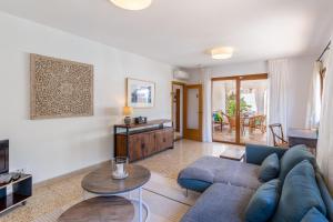 a living room with a blue couch and a table at Casa Can Picarola in Santanyi