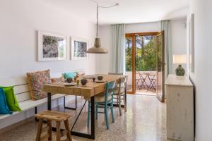 a kitchen and dining room with a table and chairs at Casa Can Picarola in Santanyi