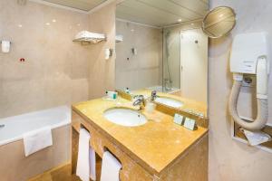a bathroom with a sink and a bath tub at Holiday Inn Lisbon by IHG in Lisbon