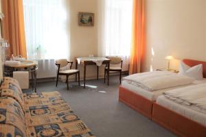 a hotel room with two beds and a table at Pension Brinn in Berlin