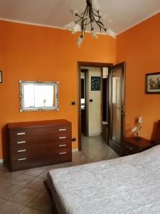 a bedroom with orange walls and a bed and a window at La Casa di Laura in Ciriè