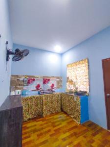 a living room with a couch and a table at Teratak Aqish, Besut Terengganu in Kampong Gong Pauh +2 photos