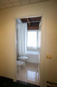 a bathroom with a toilet and a window at Hotel Candiani in Casale Monferrato