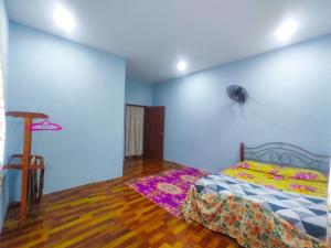 a bedroom with a bed and a wooden floor at Teratak Aqish, Besut Terengganu in Kampong Gong Pauh