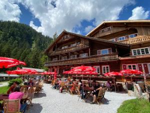 een groep mensen die aan tafels voor een gebouw zitten bij Penthaus Kitzebüheler Alpen in Neukirchen am Großvenediger