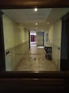 un couloir vide avec une horloge au sol dans l'établissement Hotel Castello Torre in Pietra, à Montefusco