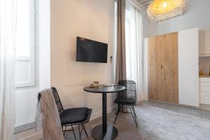カンヌにあるFlorella Maréchal Joffreのテーブルと椅子、壁にテレビが備わる客室です。