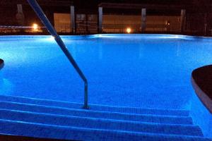 a swimming pool at night with blue lights at ATICO en la PLAYA con PISCINA y GOLF in Torre de Benagalbón