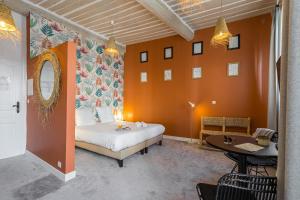 カンヌにあるFlorella Maréchal Joffreのオレンジ色の壁のベッドルーム1室、ベッド1台、テーブルが備わります。
