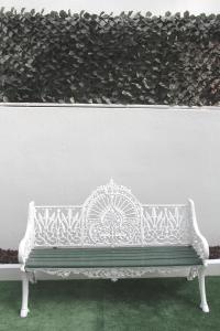 マトジニョシュにあるGenius Loci Guesthouseの白壁の前に座る白いベンチ