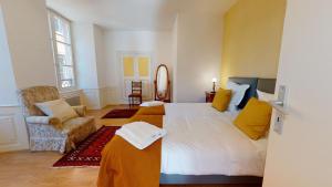 1 dormitorio con 1 cama grande y 1 silla en Chez Gasti, en Colmar