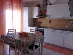 a kitchen with a table and chairs and a sink at Appartamento Pompea in Taviano
