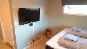 um quarto com 2 camas e uma televisão de ecrã plano em På Hjørnet Gjestehus em Skjervøy