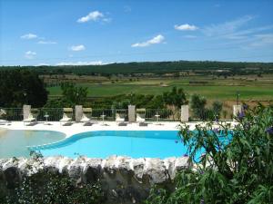 una grande piscina blu con un muro di pietra di Le Dimore della Via Lattea ad Alberobello