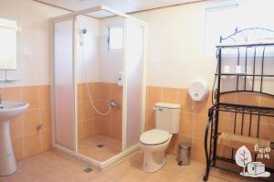 ein Bad mit einer Dusche, einem WC und einem Waschbecken in der Unterkunft Inn By Tree in Fujin
