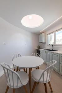 a kitchen with a table and chairs and a sink at Mykonos Divino in Tourlos