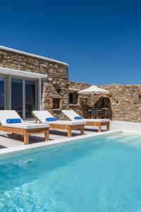 a villa with a swimming pool and patio furniture at Mykonos Divino in Tourlos