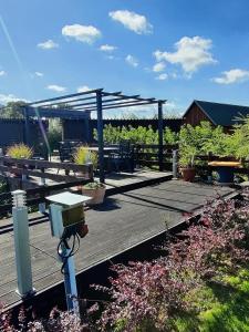 una terraza de madera con una mesa de picnic y un pabellón en Müritzblick am Wünnow en Röbel