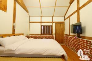 a bedroom with a white bed and a tv at Inn By Tree in Fujin