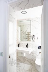 a white bathroom with a sink and a mirror at Hotel Bonaparte in Paris