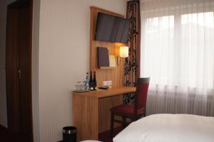 a hotel room with a bed and a desk with a television at Hotel am Bad in Tübingen +38 photos