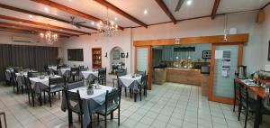 a dining room with tables and chairs in a restaurant at Dive Inn Guesthouse in Pongola