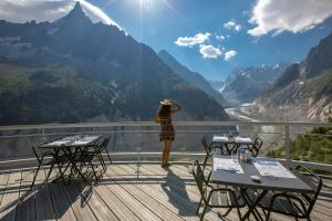 a woman standing on a balcony looking at the mountains at Refuge du Montenvers in Chamonix