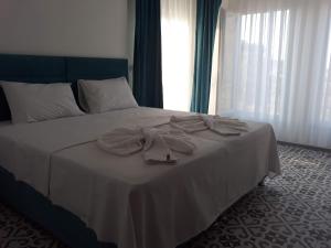 1 dormitorio con 1 cama con manta blanca y ventana en kekil butik otel, en Gokceada Town