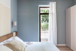 1 dormitorio con cama y ventana en San Leonardo Suites, en Verona