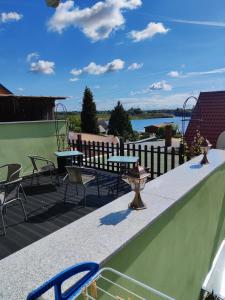 a patio with tables and chairs on a roof at Müritzblick am Wünnow in Röbel