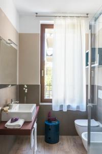 łazienka z umywalką, toaletą i oknem w obiekcie San Leonardo Suites w Weronie