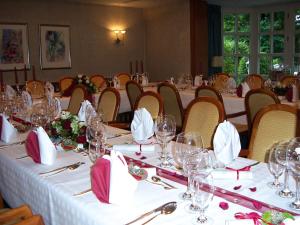 een eetkamer met tafels en stoelen met wijnglazen bij Schaperkrug in Celle