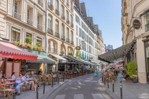 a city street with tables and chairs and buildings at Hotel Bonaparte in Paris