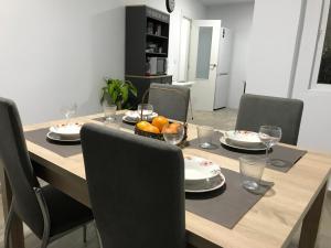 a dining room table with chairs and a wooden table with food on it at Espacioso y céntrico piso con zona chill-out in Alicante