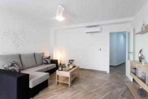 uma sala de estar com um sofá e uma mesa em Espacioso y céntrico piso con zona chill-out em Alicante