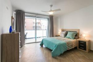 ein Schlafzimmer mit einem Bett und einem großen Fenster in der Unterkunft Espacioso y céntrico piso con zona chill-out in Alicante