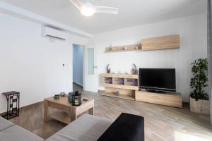 ein Wohnzimmer mit einem Flachbildfernseher an der Wand in der Unterkunft Espacioso y céntrico piso con zona chill-out in Alicante