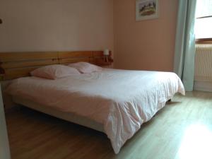 a bedroom with a bed with white sheets and a window at Auberge du Grand Joly in Sainte-Agnès