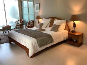 a bedroom with a large bed with white sheets and pillows at Chambre à louer au coeur d'Arcachon in Arcachon +14 photos