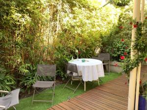 a table and chairs on a deck in a garden at Chambre à louer au coeur d'Arcachon in Arcachon