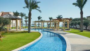 basen w ośrodku z altaną i palmami w obiekcie InterContinental Hotels Doha Residences w mieście Doha