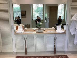 a bathroom with two sinks and a woman in a mirror at Chambre à louer au coeur d'Arcachon in Arcachon