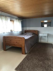 1 dormitorio con cama y techo de madera en Rukan Tähtihelmi Kelokivakka b12, en Ruka